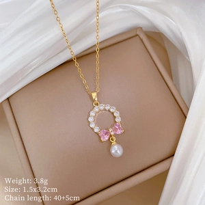 Detail of bow pendant with pink heart stones and pearl on luxury jewelry display