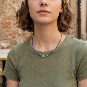 Detail of bohemian MGB glass bead necklace with freshwater pearl pendant on model