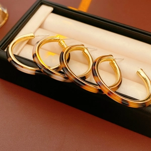 Close-up of retro tortoiseshell resin C-shape hoop earrings in a black display gift box