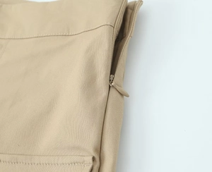Detail shot of khaki cargo skirt featuring a hidden zipper and fine stitching texture