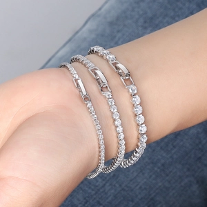 Trois bracelets tennis en argent 925 avec zircons blancs portés sur une manche en denim