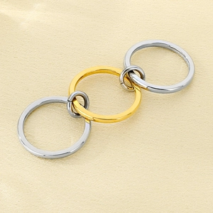Close-up of interlocking polished gold and silver rings on elegant silk fabric