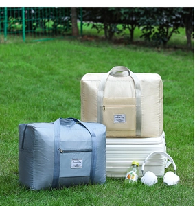 Macro shot of waterproof quilted travel bags in grey-blue and beige on a suitcase