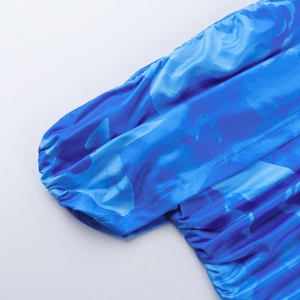 Détail de la robe à imprimé floral bleu montrant la texture froncée et le tissu soyeux