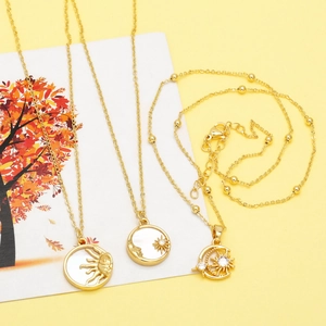 Detail of vintage gold sun and moon necklaces with mother-of-pearl and crystal accents