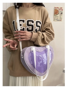 Lifestyle view of a purple heart-shaped ita bag with a clear window for display