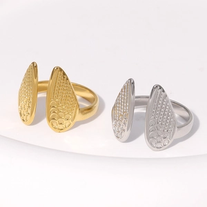 Detailed macro view of the wing-shaped texture on gold and silver stainless steel rings
