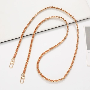 Detail of gold metal chain woven with brown leather strap and dual lobster clasps