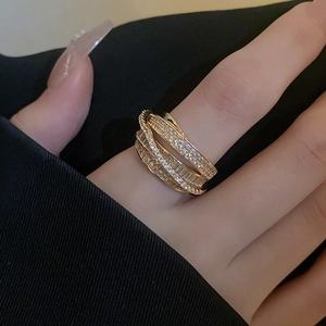 Detail of multi-layer gold ring with zircons worn on finger for a stylish luxury look