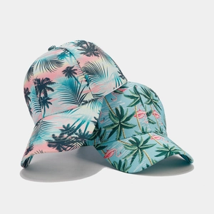 Detail of tropical print baseball caps featuring palm trees and flamingos on white