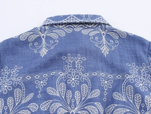 Détail de la broderie florale blanche sur le dos bleu de cette robe chemise française