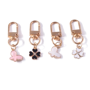 Golden butterfly and clover keychain set with pink and black enamel pendants