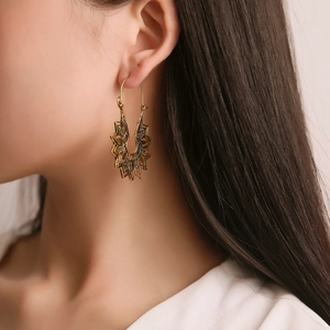 Gros plan de boucles d'oreilles ethniques dorées avec motif mandala ajouré