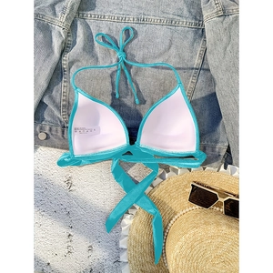 Detail of teal halter bikini top featuring removable pads and nylon spandex blend fabric