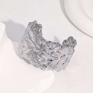 Polished silver stainless steel wide cuff bracelet with embossed daisy floral patterns