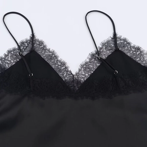 Dettaglio dello scollo a V in pizzo e tessuto di raso setoso sul top nero