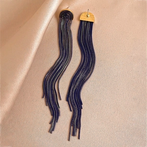 Elegant gold semi-circle earrings with cascading blue and silver chain tassels on silk