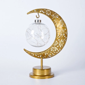 Détail de la lampe de table en métal doré en forme de lune avec boule en verre LED