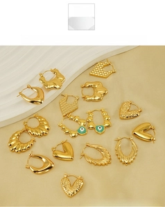 Flat lay of vintage gold earrings with heart shapes and evil eye enamel details