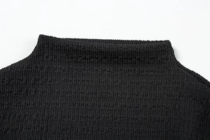 Détail de la texture froncée et du tissu plissé élastique sur la robe noire