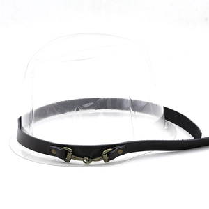 Detail of dark leather hat band featuring a bronze metal horse bit buckle and metal rivets