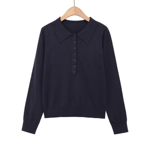 Dettaglio di polo in maglia blu navy a maniche lunghe con abbottonatura frontale