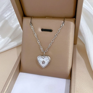 Silver stainless steel heart necklace with star shell inlay in a beige jewelry box