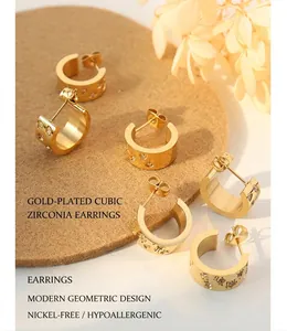 Detail view of C-shaped 18K gold-plated titanium earrings with inlaid zircon on book page