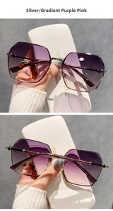Close-up of rimless gradient purple pink sunglasses with a polygon gold metal frame