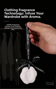 White camellia plaster diffuser with black ribbon hanging in a wardrobe closet