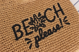 Détail du sac de plage en paille avec broderie en peluche noire BEACH please