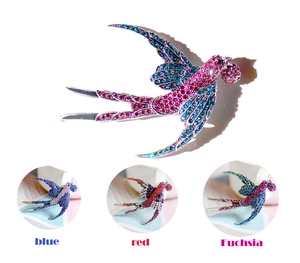 Dettaglio delle spille a forma di rondine con strass colorati in tre varianti di colore