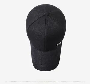 Top down view of black baseball cap showing six-panel crown and metal logo detail