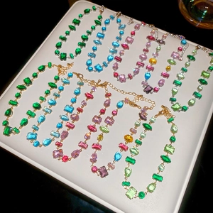 Detailed view of colorful geometric zircon bracelets with mixed shapes on a white tray