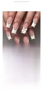 Detail of French press-on nails featuring 3D white bows and elegant pearl accents