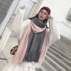 Pink and grey color-block knit scarf with long tassels worn by a model outdoors
