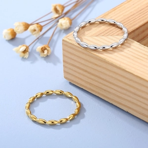 Detail of minimalist gold and silver beaded stackable rings with polished grain texture