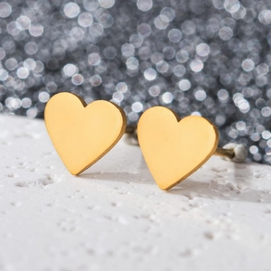 Macro shot of gold heart-shaped stainless steel stud earrings with high gloss finish