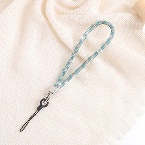 Elegant silver and blue rhinestone phone strap chain with metal clasp on beige fabric