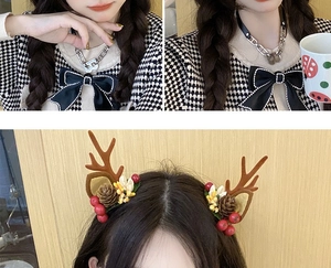 Detail of Christmas reindeer antler hair clips with pine cones and red berries on a model