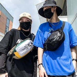 Outdoor lifestyle shot of black and multi-color crossbody chest bags on male and female models