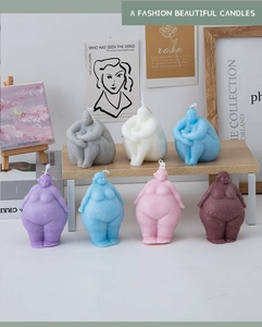 Artistic display of multicolored female torso candles on a bookshelf with decor
