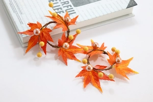 Close-up of harvest maple leaf napkin rings with pearls and berries for autumn table decor