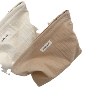 Minimalist cotton striped cosmetic bag in cream and khaki colors with pleated texture
