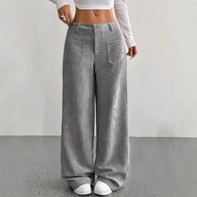 Detail of light gray corduroy high-waisted wide-leg pants on model in studio