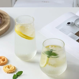 Detailed view of vertical ribbed glass cups with lemon, mint, and ice for cold drinks