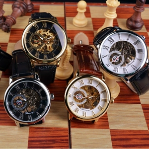 Retro skeleton mechanical watch set with gold and silver cases on a chess board