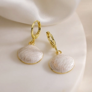Retro 18K gold plated drop earrings with white shell pattern pendants on a display stand