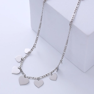 Minimalist silver heart pendant necklace with Figaro chain on a white aesthetic background