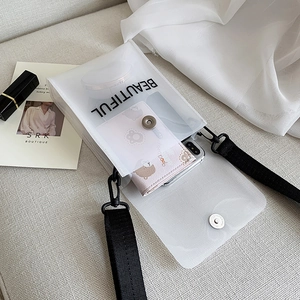 Dettaglio della borsa a tracolla in PVC trasparente con stampa del testo 'BEAUTIFUL'
